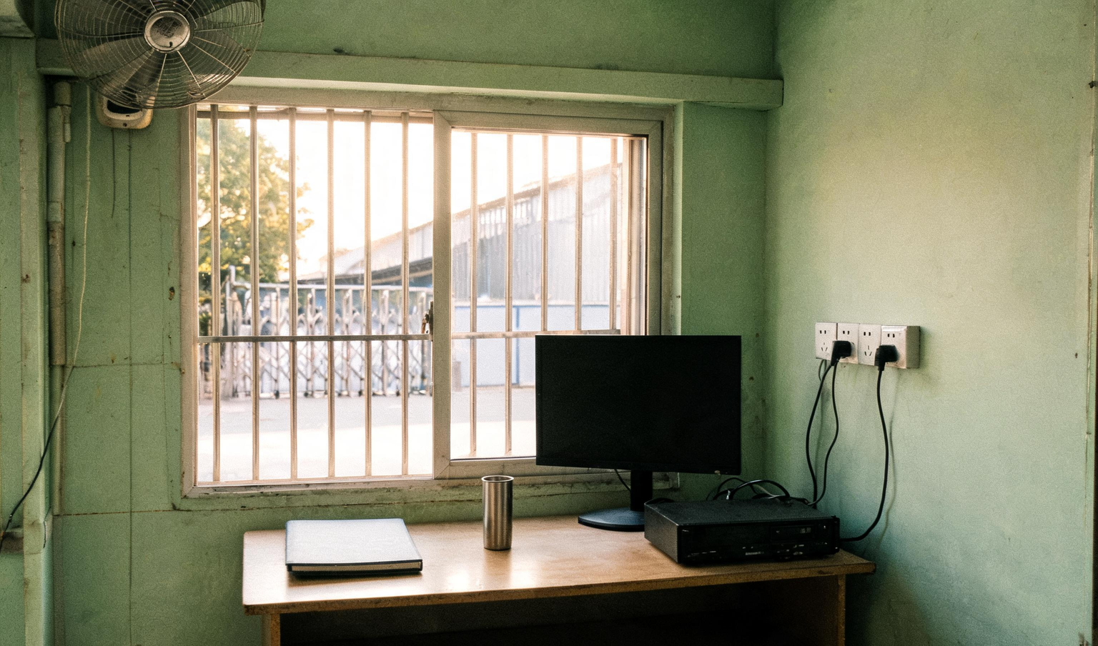 Security cabin at a Tamil Nadu factory gate with a CCTV recorder, a switched-off monitor and a closed register on the desk