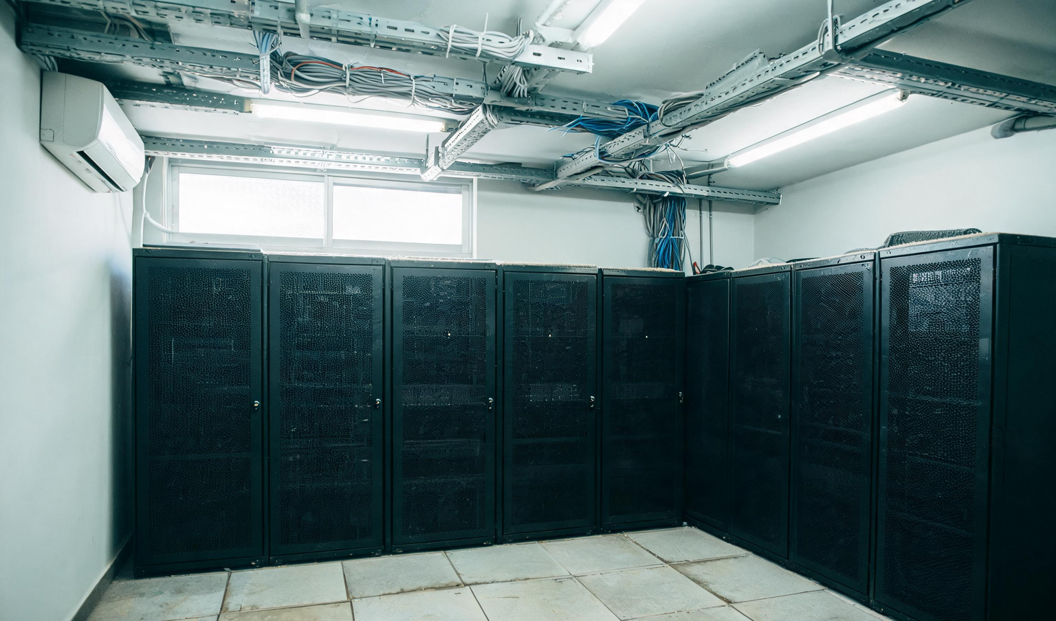 Locked server racks and overhead cable trays in the server room of a Tamil Nadu manufacturing company
